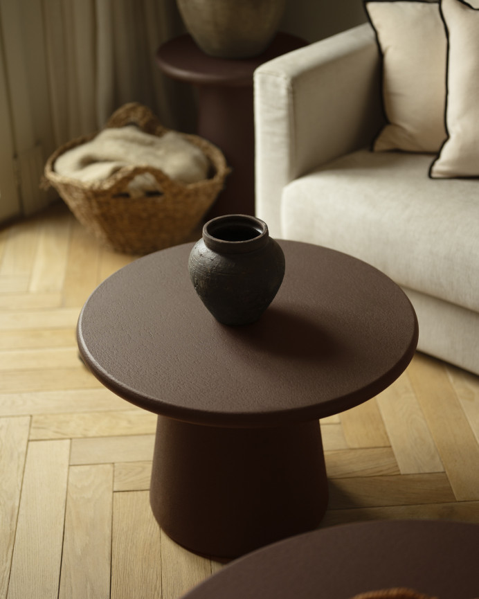 Round coffee table made of microcement in brown tones available in various sizes.