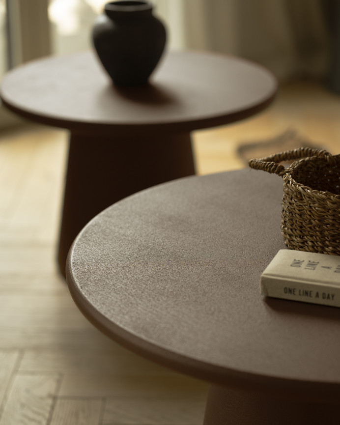 Round coffee table made of microcement in brown tones available in various sizes.