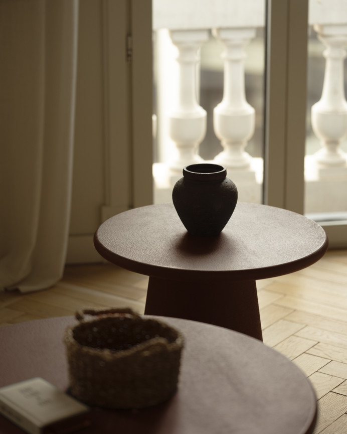 Round coffee table made of microcement in brown tones available in various sizes.