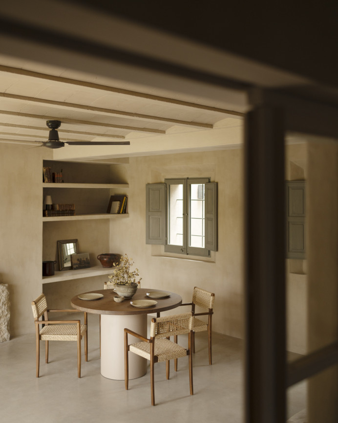 Round solid wood dining table in a dark oak tone with earth-tone micro-cement legs in various sizes.