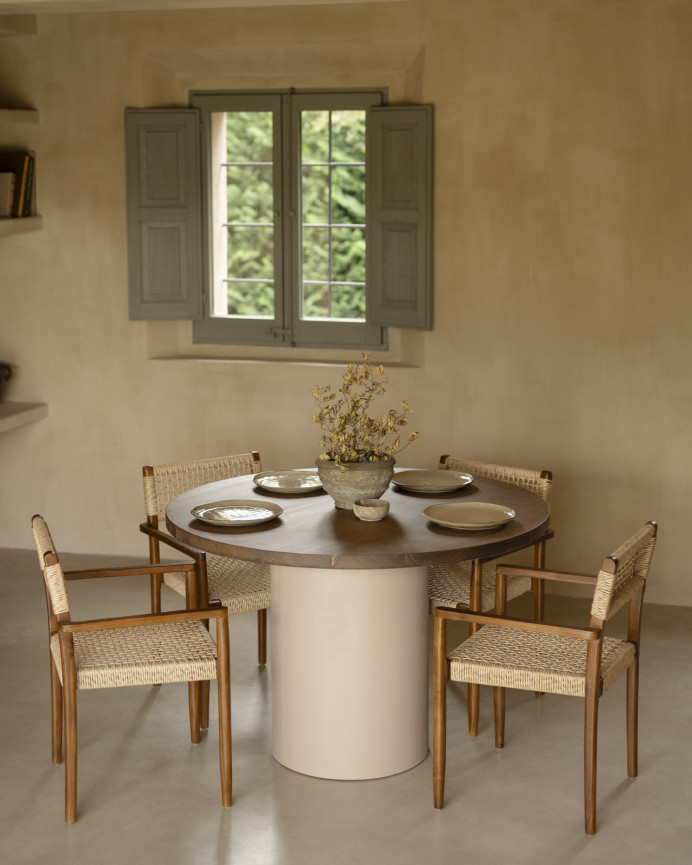 Round solid wood dining table in a dark oak tone with earth-tone micro-cement legs in various sizes.