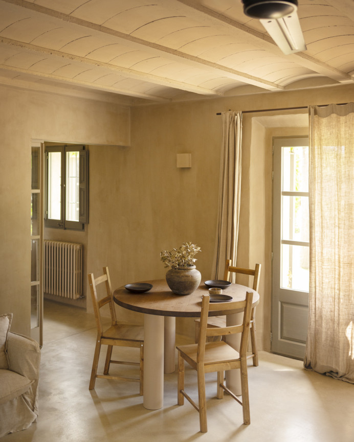Round solid oak wood dining table with dark oak tone and earth-tone microcement legs available in various sizes.