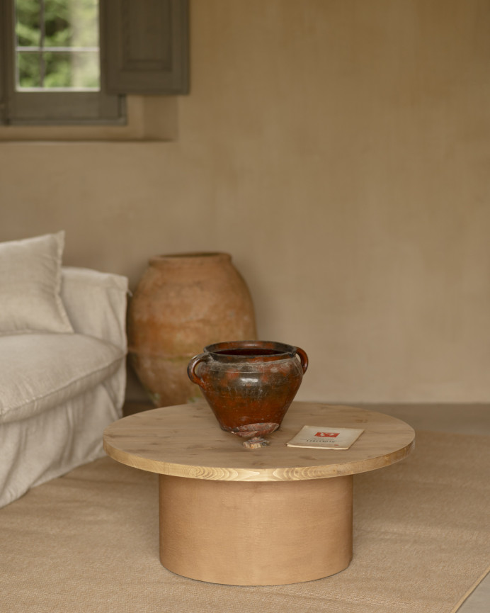 Round solid wood coffee table in medium oak tone with terracotta microcement leg measuring 80x33cm.