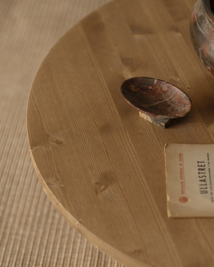 Round solid wood coffee table in medium oak tone with terracotta microcement leg measuring 80x33cm.