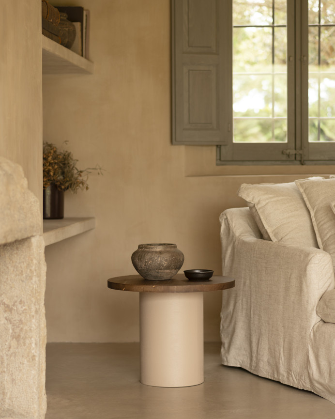 Round solid wood coffee table in a dark oak tone with a earth-tone microcement leg, available in various sizes.