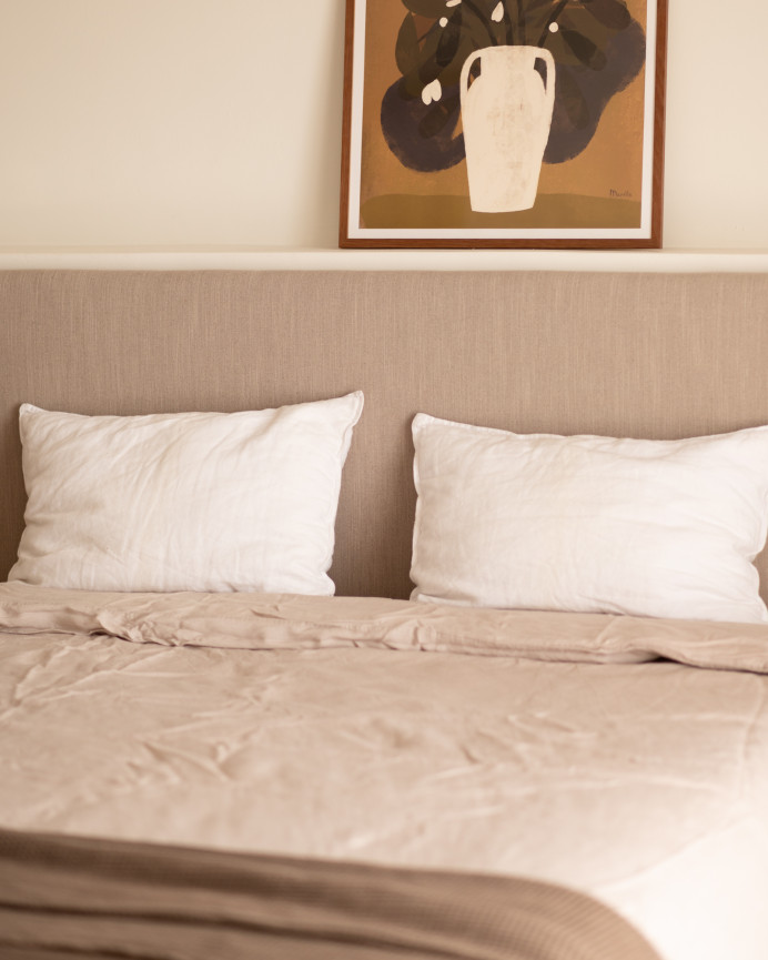 Upholstered headboard in plain polyester in cinnamon color in various sizes.
