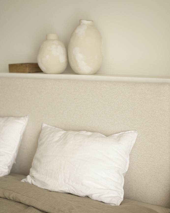 Upholstered headboard in plain beige polyester of various sizes.