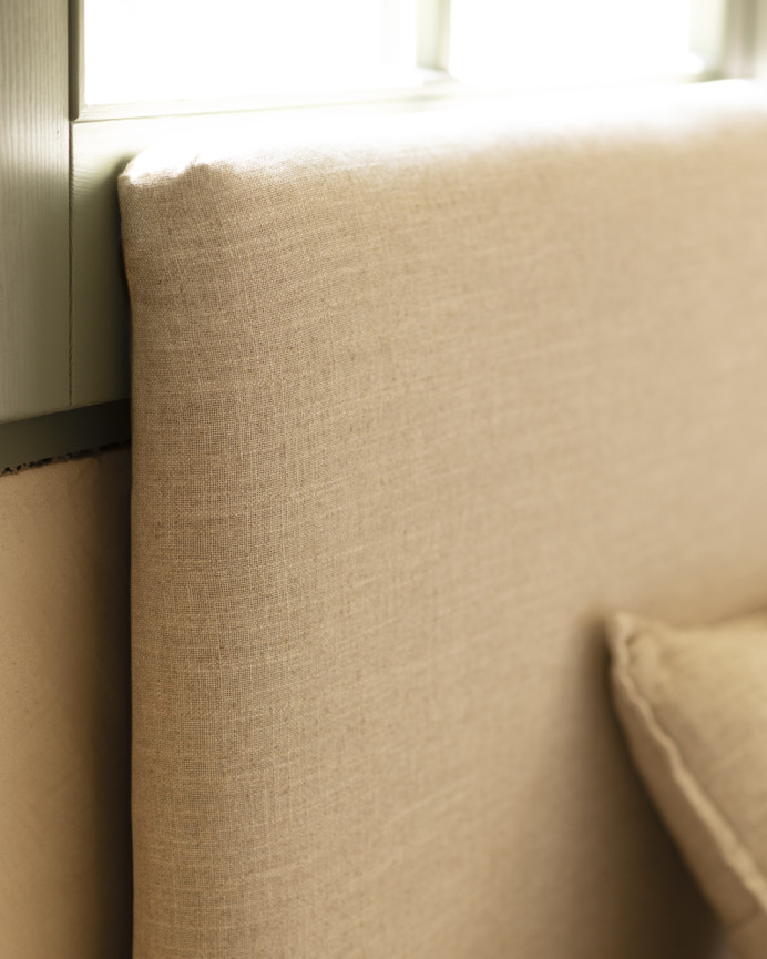 Upholstered beige linen bed frame for mattress of various sizes.
