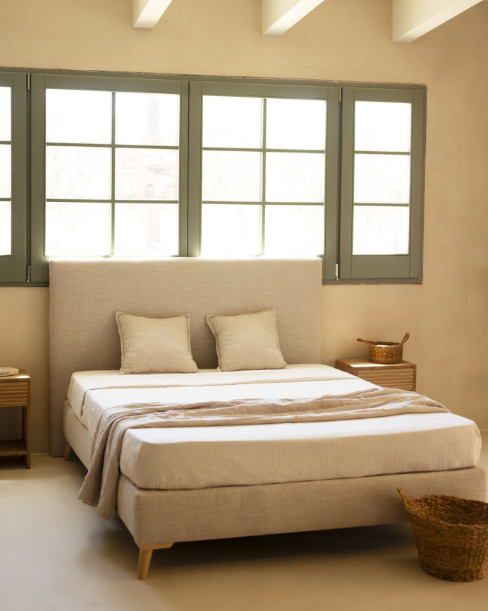 Upholstered beige linen bed frame for mattress of various sizes.
