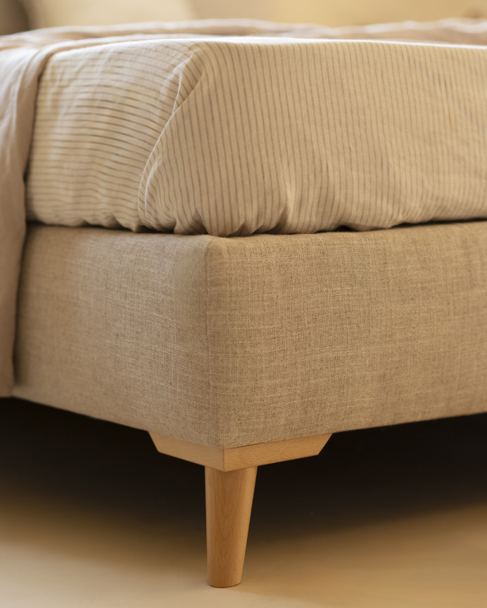 Upholstered beige linen bed frame for mattress of various sizes.