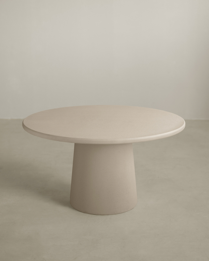 Round beige microcement dining table available in various sizes.