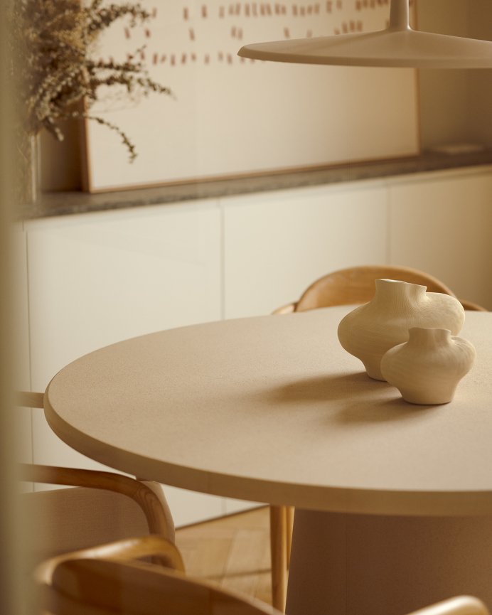 Round beige microcement dining table available in various sizes.