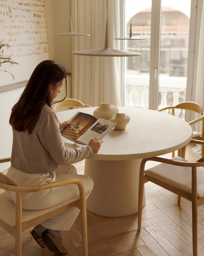 Round beige microcement dining table available in various sizes.