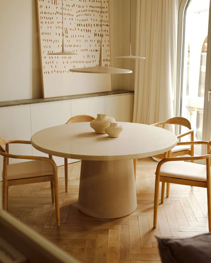 Round beige microcement dining table available in various sizes.
