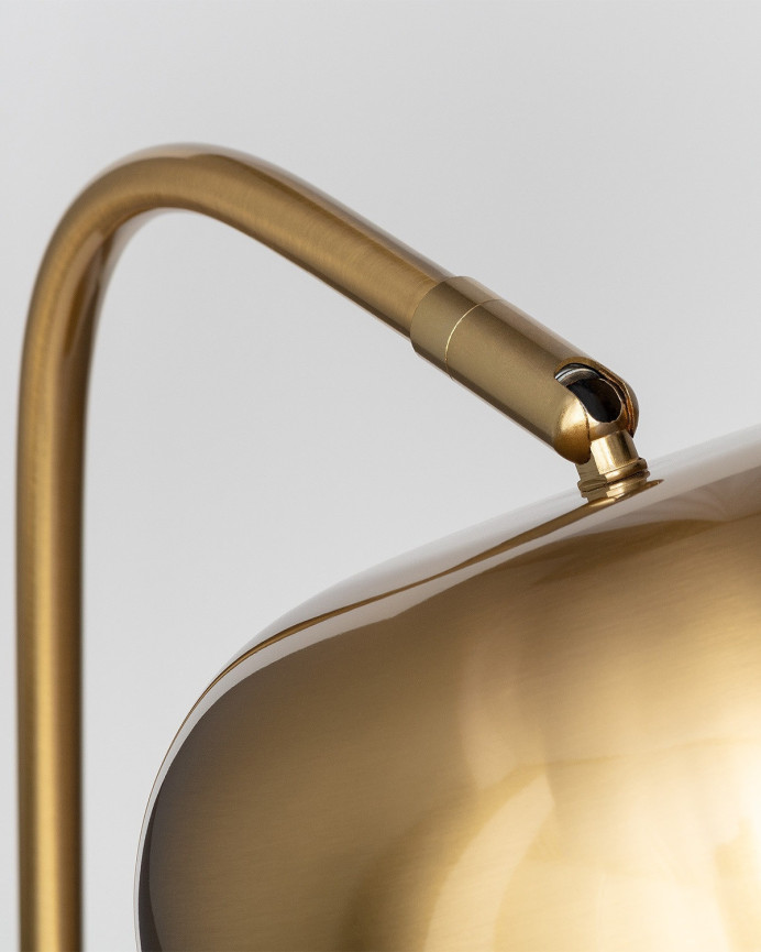 Lámpara de mesa elaborada con hierro acabado dorado y negro.