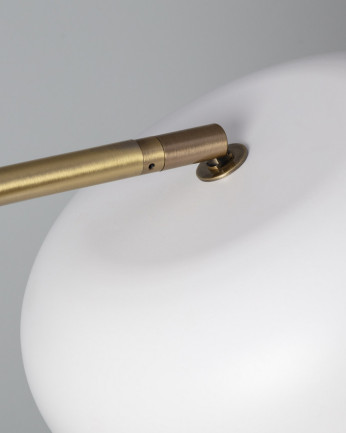 Lámpara de pie elaborada con base metálica color blanco y dorado.