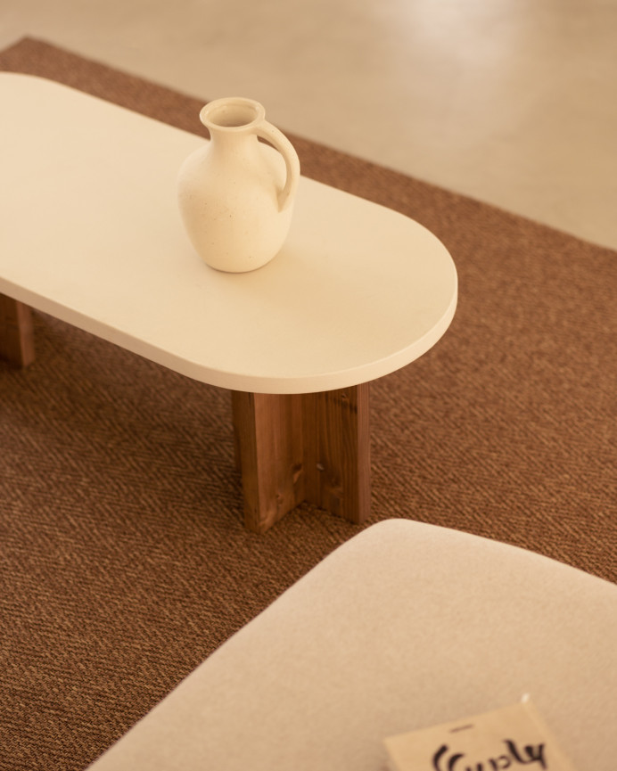 Mesa de centro de microcemento en tono blanco roto con patas de madera tono roble oscuro de 120x40cm