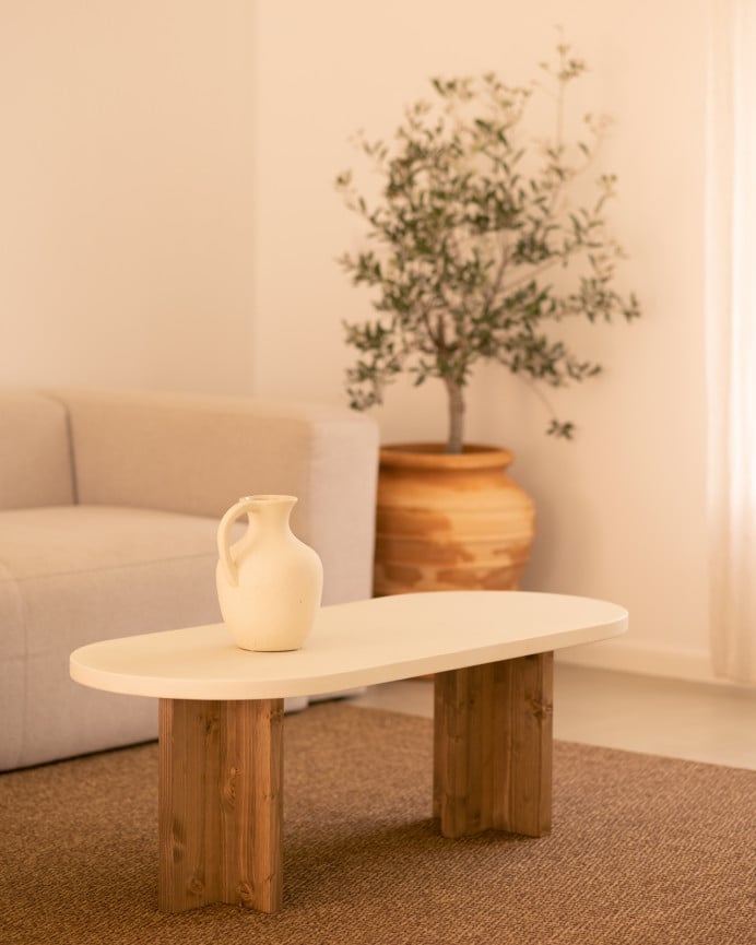 Mesa de centro de microcemento en tono blanco roto con patas de madera tono roble oscuro de 120x40cm