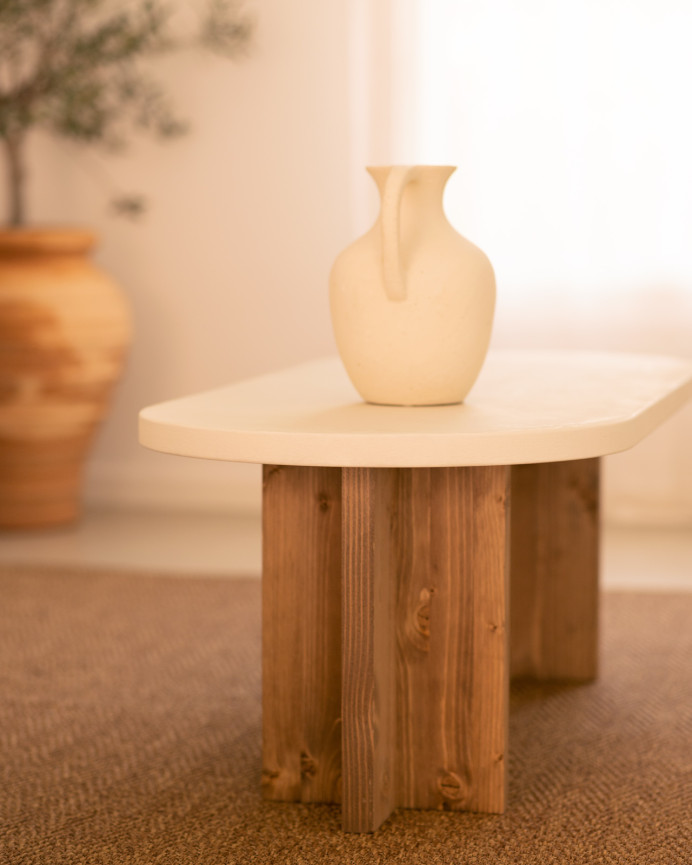 Mesa de centro de microcemento en tono blanco roto con patas de madera tono roble oscuro de 120x40cm