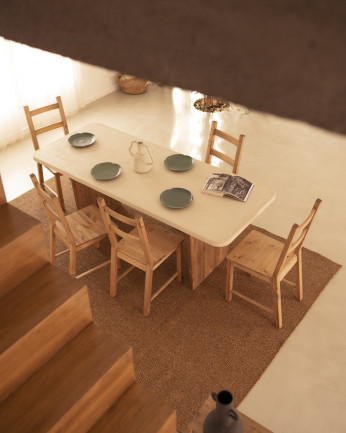 Table de salle à manger en microciment, de couleur blanc cassé avec des pieds en bois de chêne foncé de différentes taille