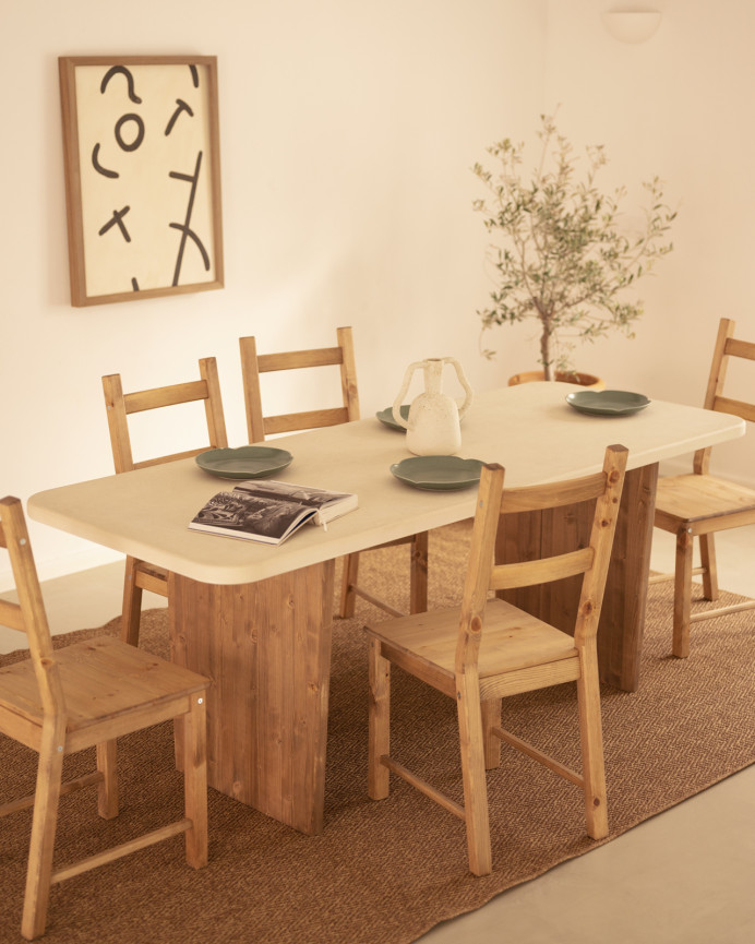 Table de salle à manger en microciment, de couleur blanc cassé avec des pieds en bois de chêne foncé de différentes taille