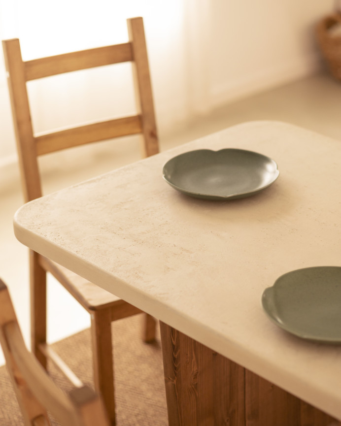 Table de salle à manger en microciment, de couleur blanc cassé avec des pieds en bois de chêne foncé de différentes taille