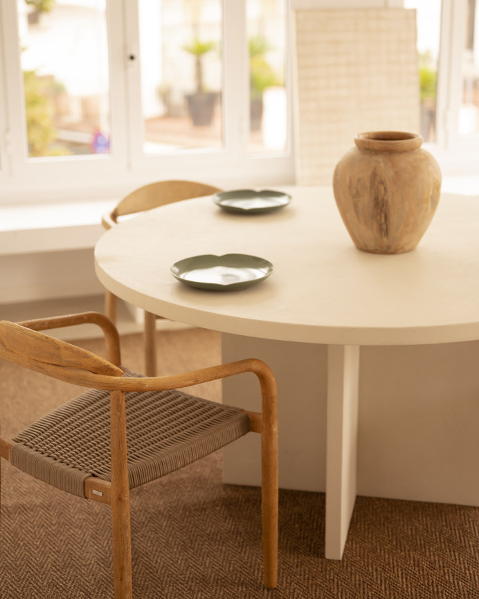 Table de salle à manger ronde en microciment de teinte blanc cassé disponible en plusieurs dimensions.