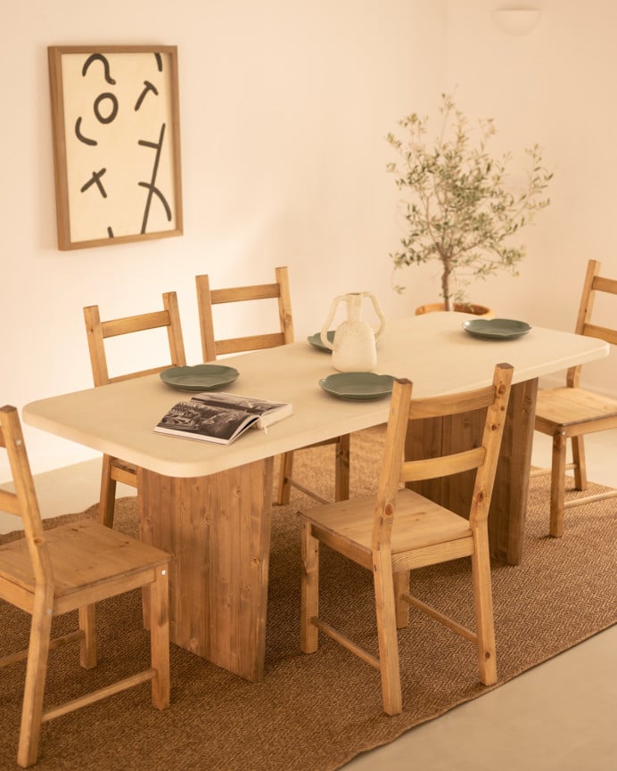 Table de salle à manger en microciment, de couleur blanc cassé avec des pieds en bois de chêne foncé de différentes taille