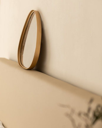 Specchio realizzato in metallo con finitura dorata.