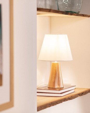 Lampada da tavolo realizzata con base in legno e paralume in tessuto di colore bianco.