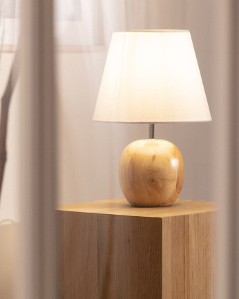 Lampada da tavolo realizzata con base in legno e paralume in tessuto di colore bianco.