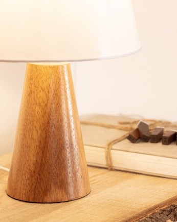 Lampada da tavolo realizzata con base in legno e paralume in tessuto di colore bianco.