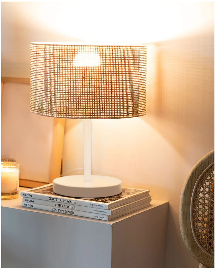 Lampada da tavolo realizzata con base metallica di colore bianco e paralume in rattan.