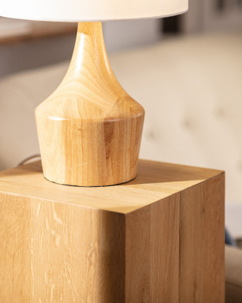 Lampada da tavolo realizzata con base in legno e paralume in tessuto bianco.