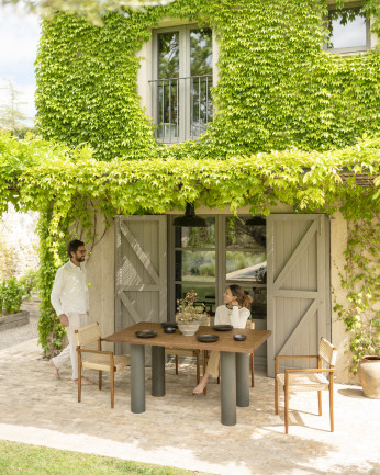 Tavolo da pranzo in legno massello in tonalità di rovere scuro e gambe in microcemento in tonalità verde di varie dimensioni.